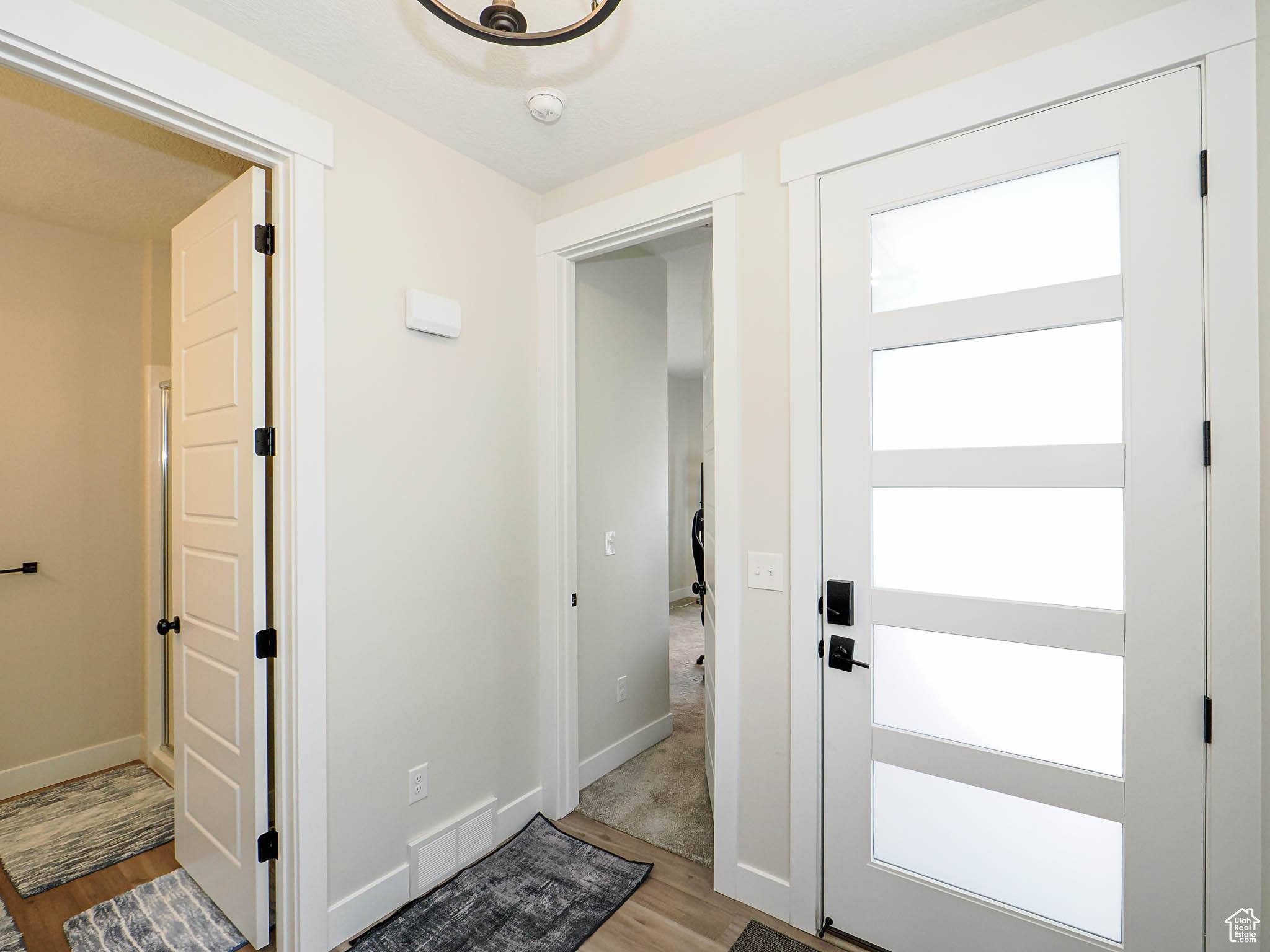 Foyer entrance featuring baseboards, visible vents, and wood finished floors