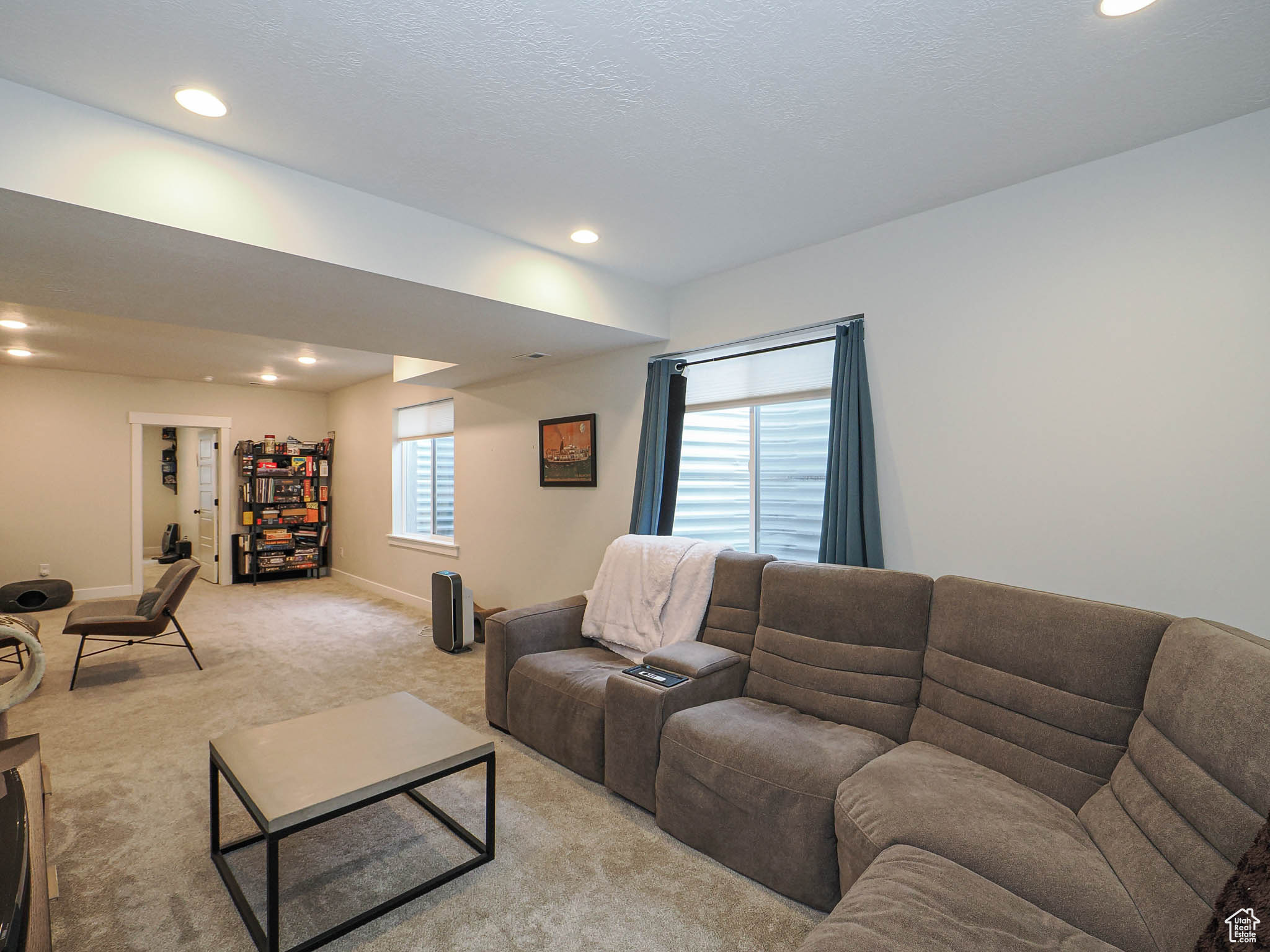 Living room featuring recessed lighting, light carpet, a textured ceiling, and baseboards
