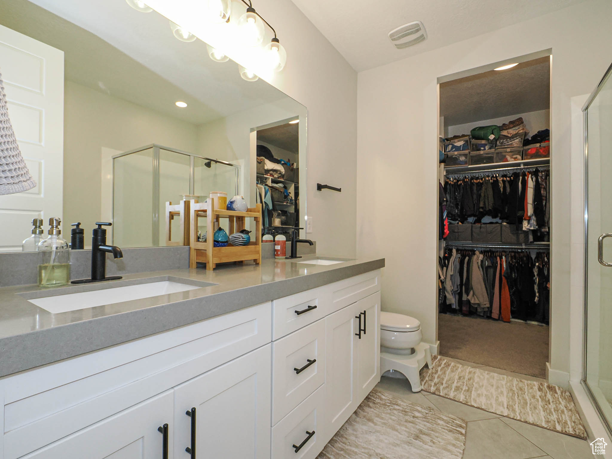 Full bathroom featuring tile patterned flooring, a spacious closet, visible vents, and a sink