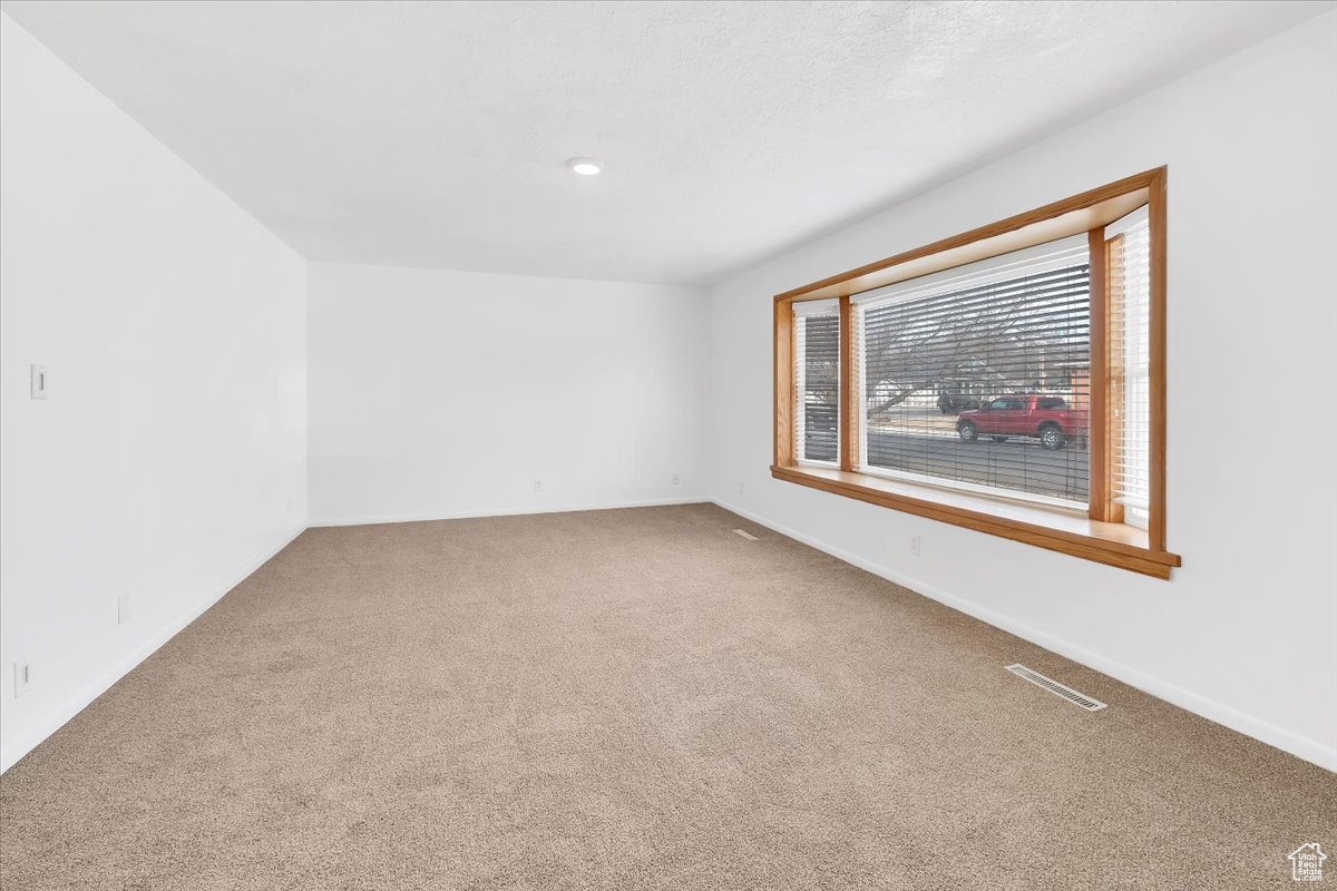 Living area carpet floors, a textured ceiling, and baseboards