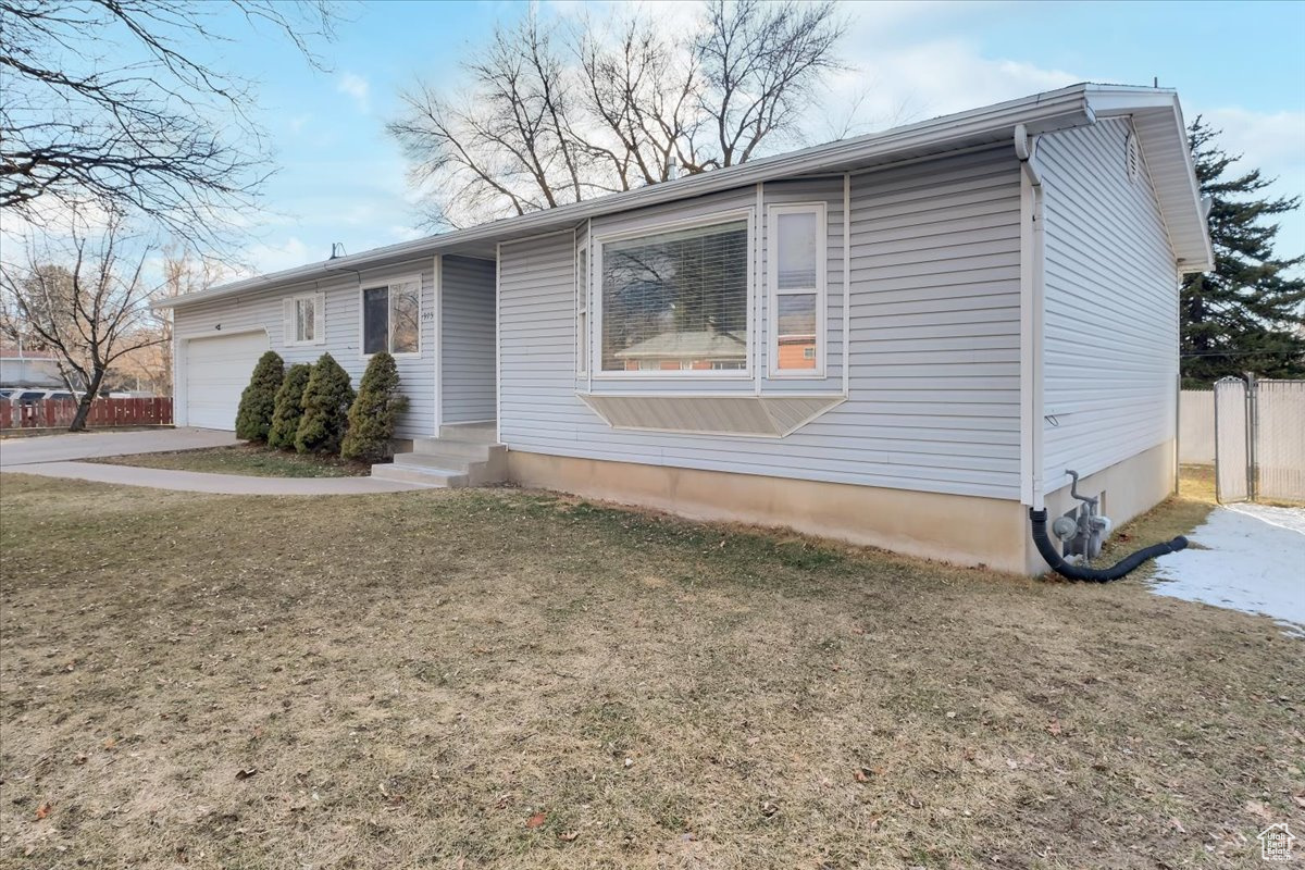 Single story home with a front yard, fence, and a garage
