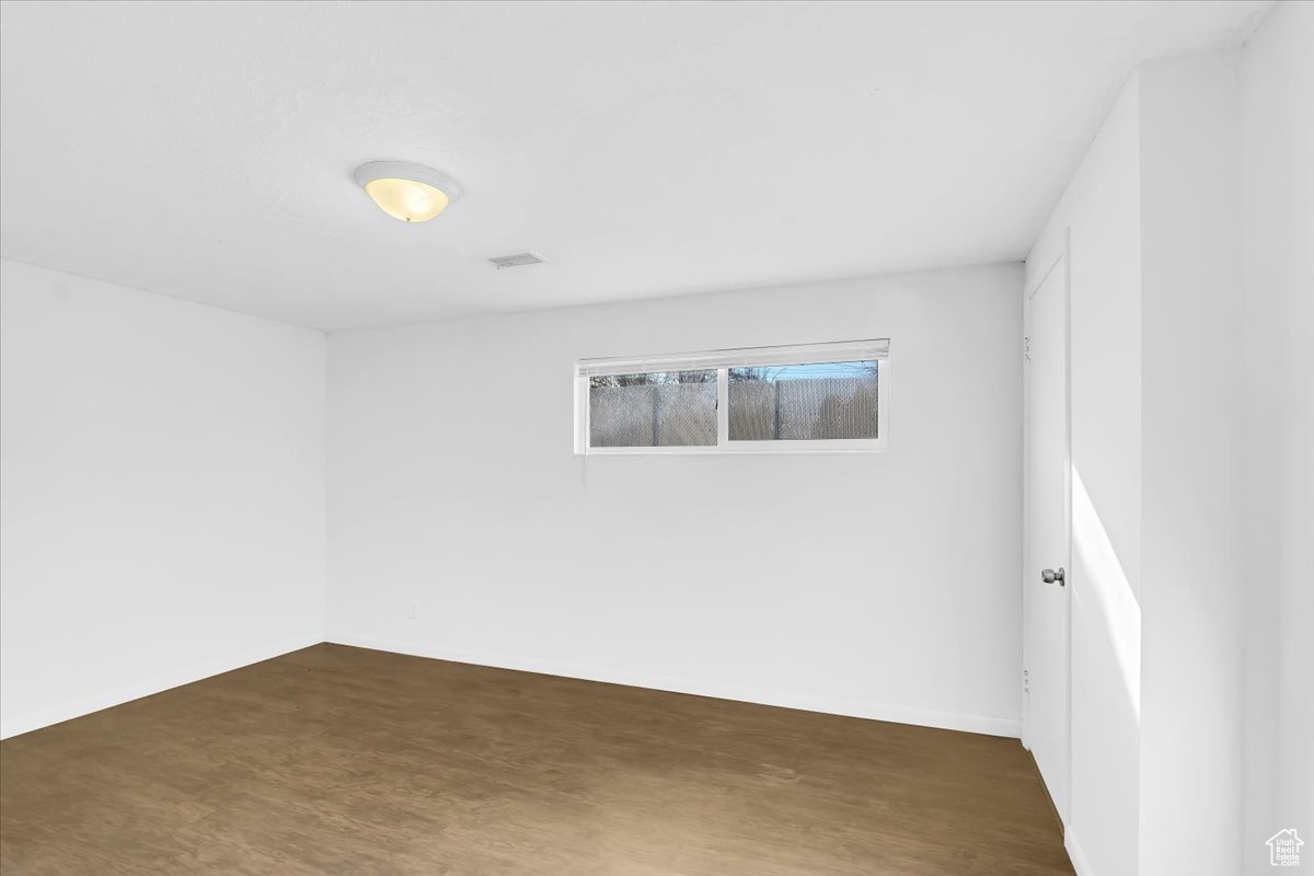 Spare room featuring dark wood-style floors