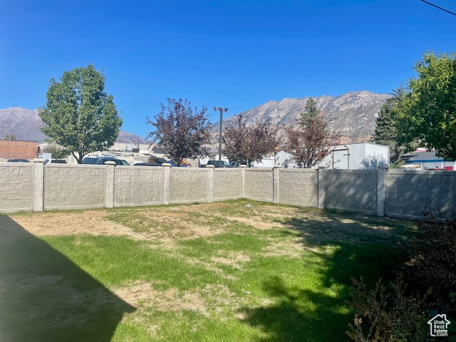 View of yard featuring a mountain view and fence