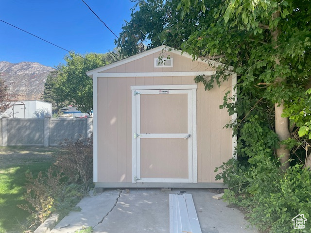 View of shed featuring a mountain view and fence