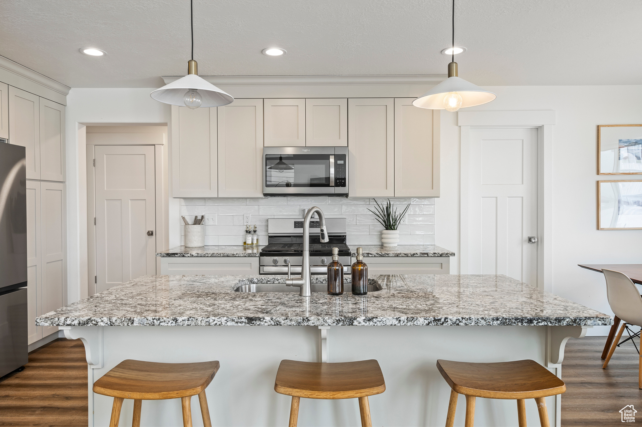 Kitchen featuring tasteful backsplash, a sink, stainless steel appliances, and dark wood-style flooring