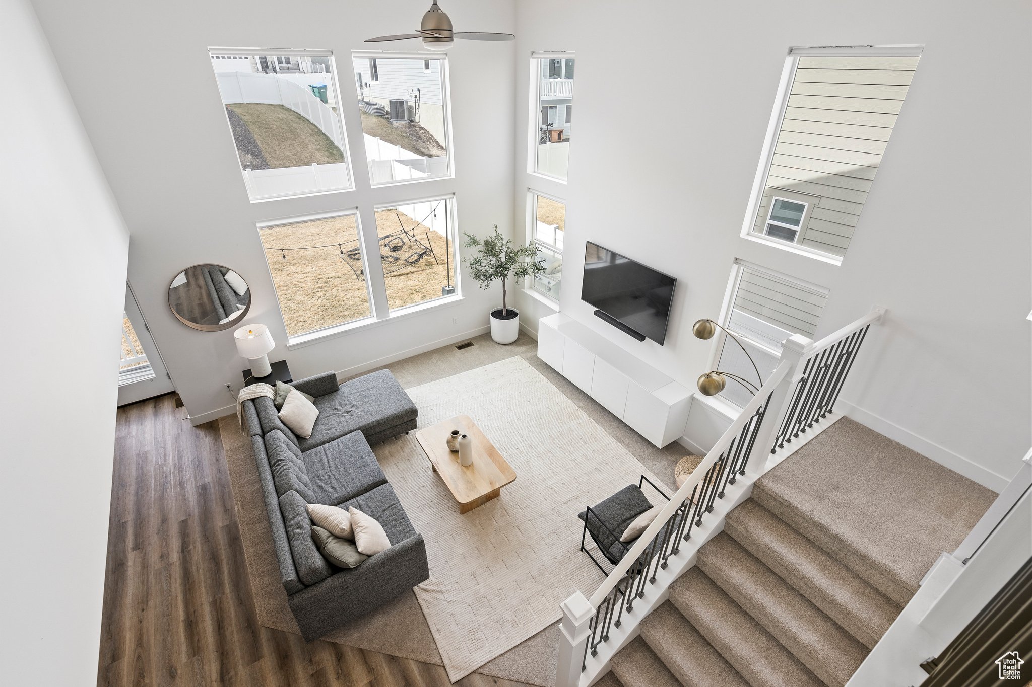 Living area with stairs, a high ceiling, a healthy amount of sunlight, and baseboards