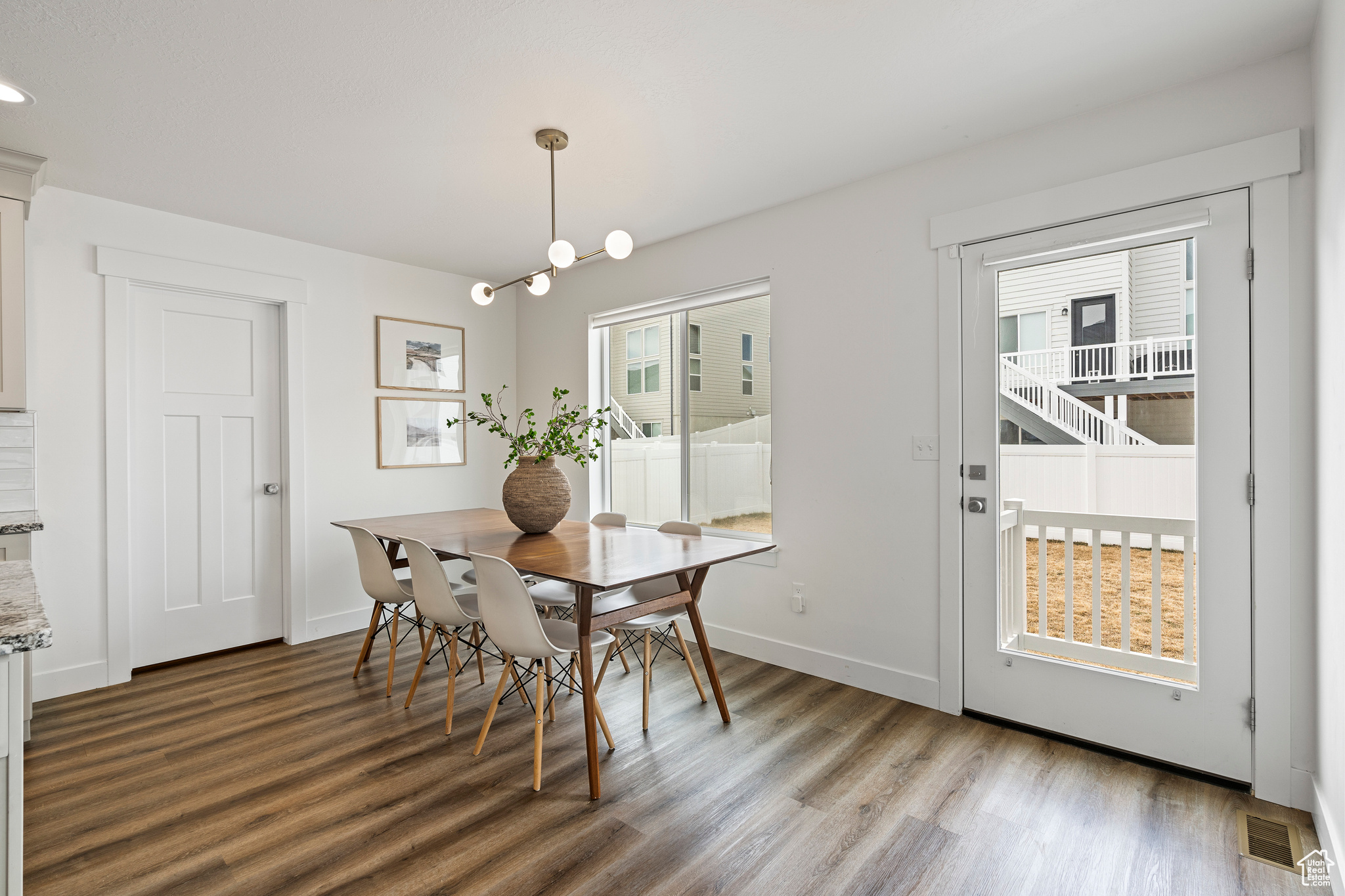 Dining space with visible vents, wood finished floors, and baseboards