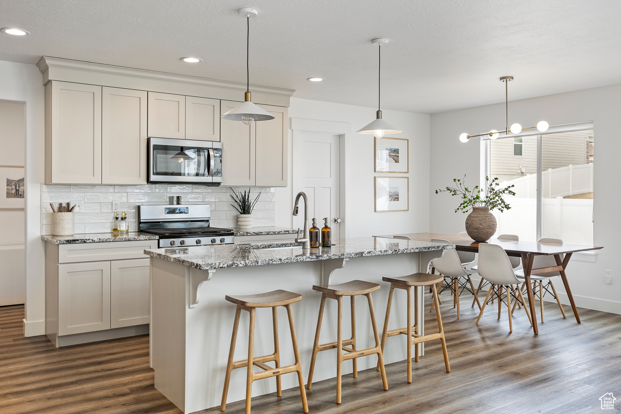Kitchen featuring a sink, stainless steel appliances, dark wood-type flooring, and decorative backsplash