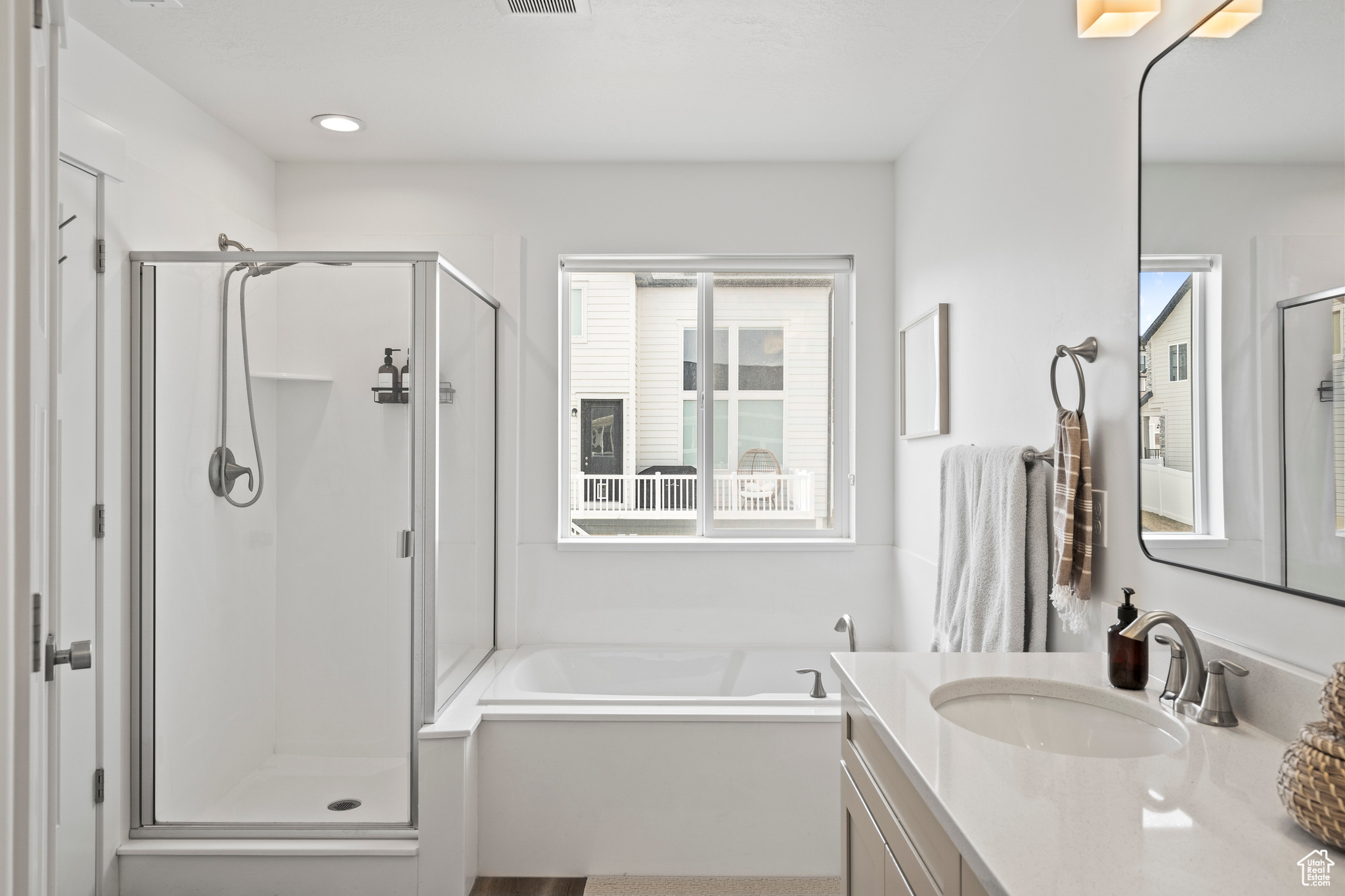 Bathroom with a healthy amount of sunlight, a stall shower, and vanity