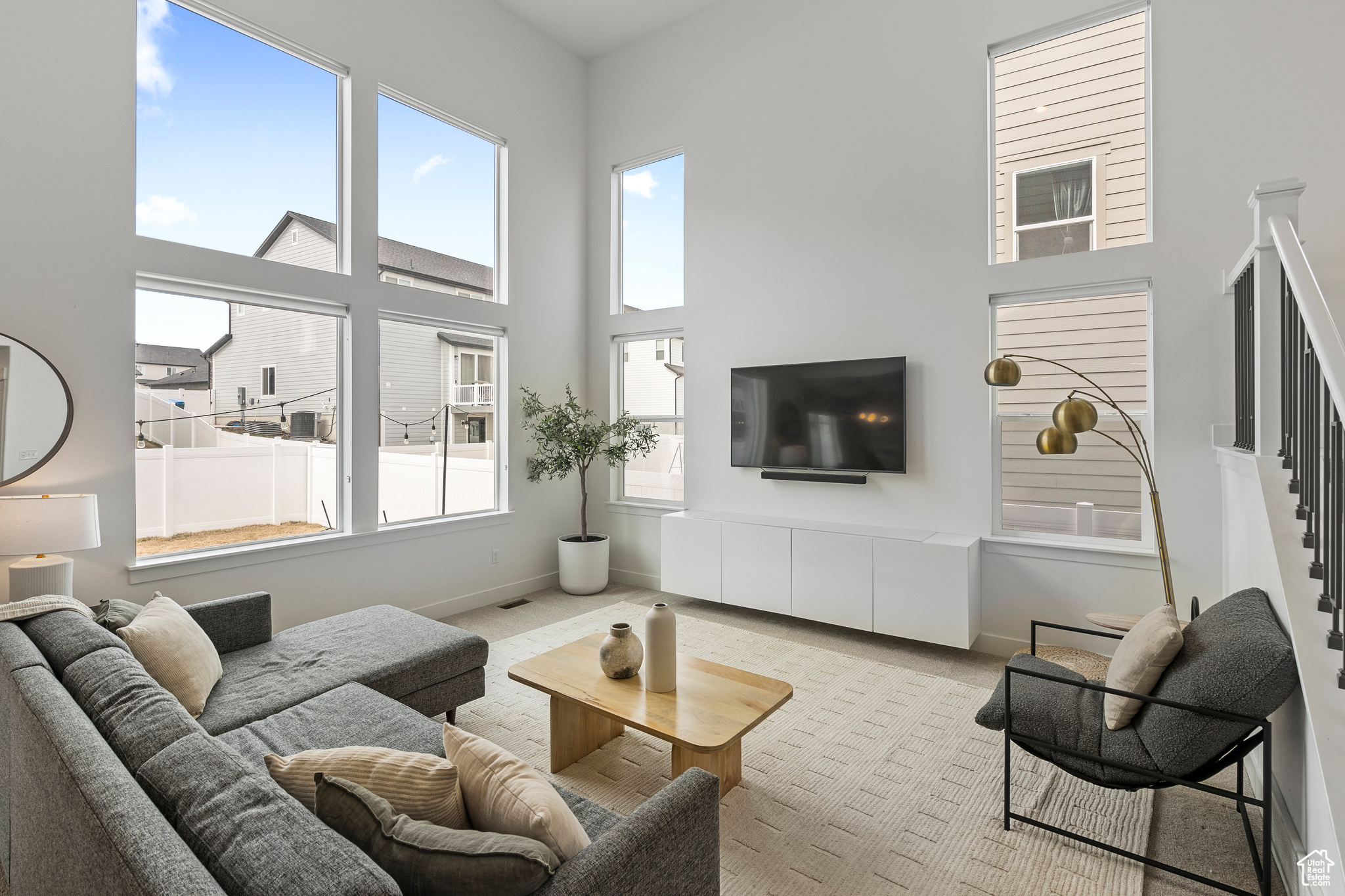 Living room featuring baseboards, a high ceiling, a healthy amount of sunlight, and carpet