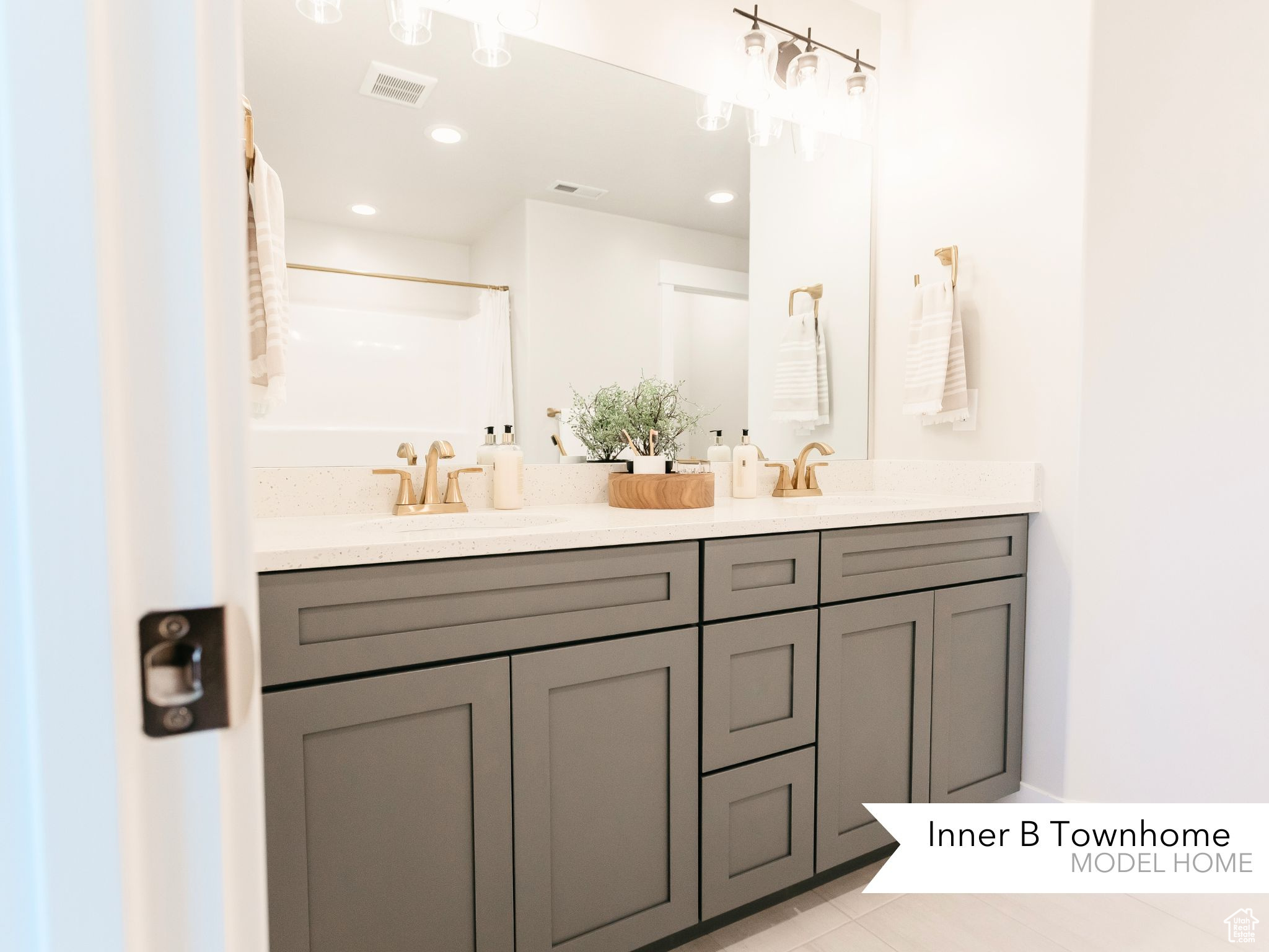 Bathroom with double vanity, visible vents, and a sink