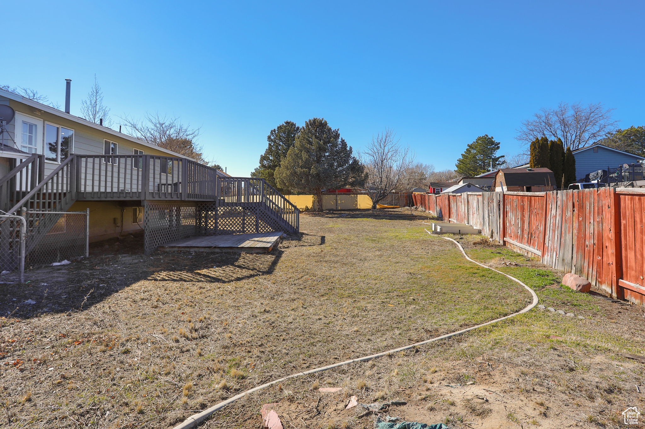 View of yard with a deck, a fenced backyard, and stairs