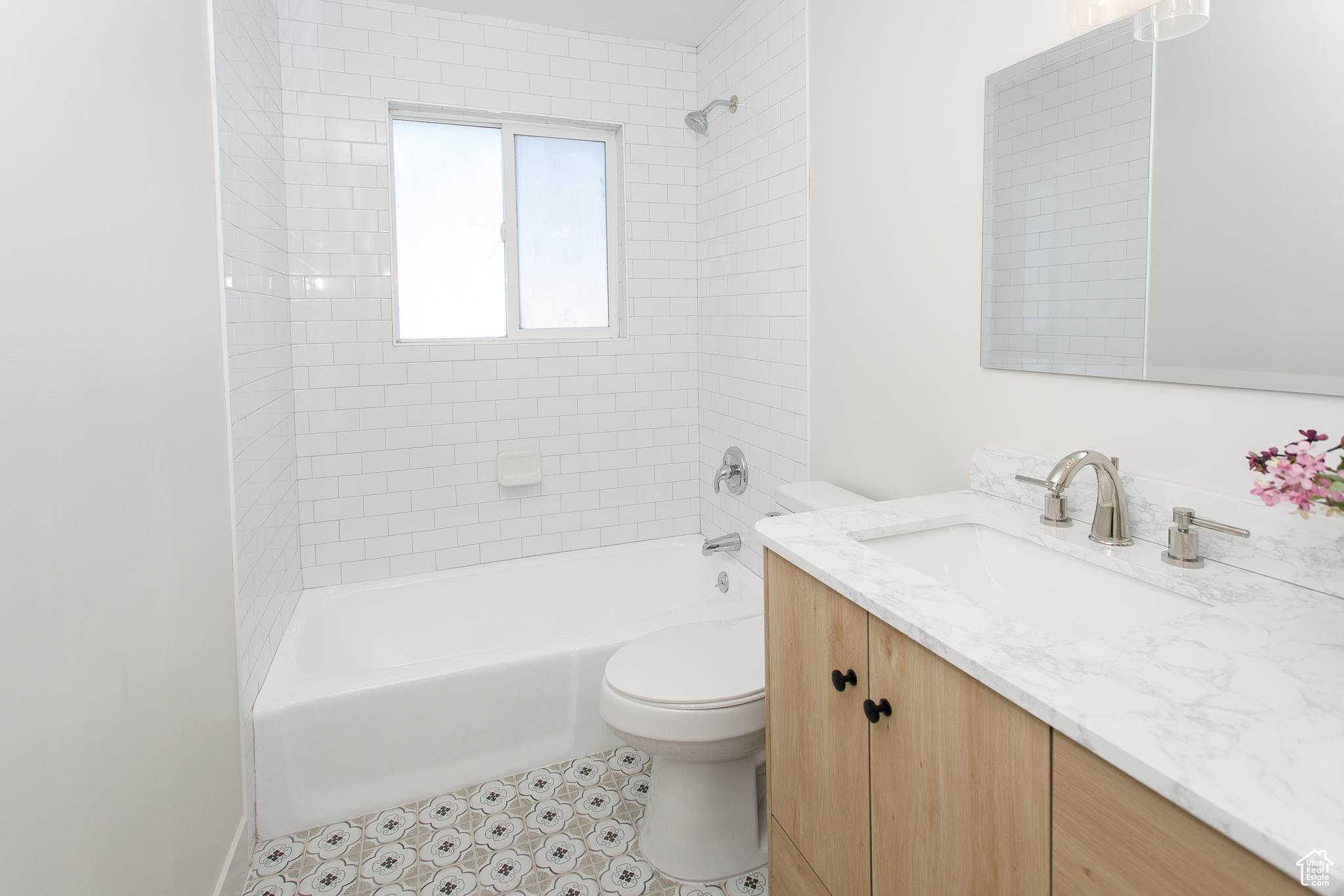 Remodeled bathroom with new subway tile, stylish floor tile, new vanity, light fixture, mirror etc