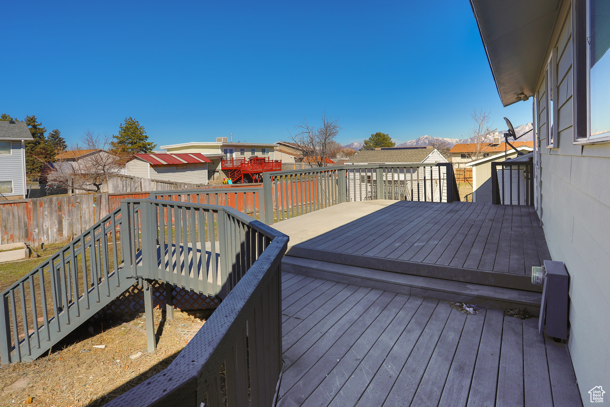 Deck with a residential view, a storage shed, an outdoor structure, and fence