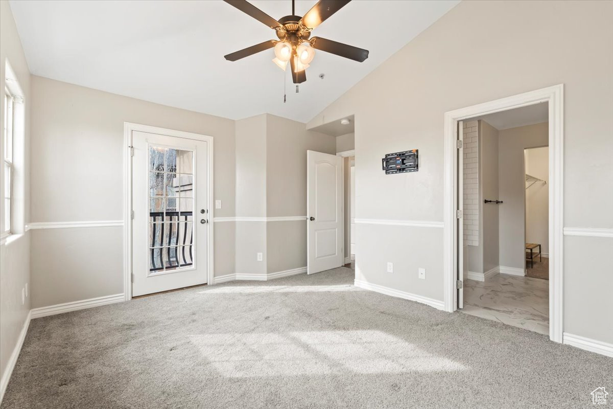 Unfurnished bedroom with carpet flooring, high vaulted ceiling, baseboards, and a ceiling fan