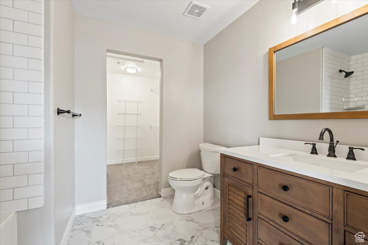 Full bath featuring visible vents, toilet, marble finish floor, baseboards, and vanity