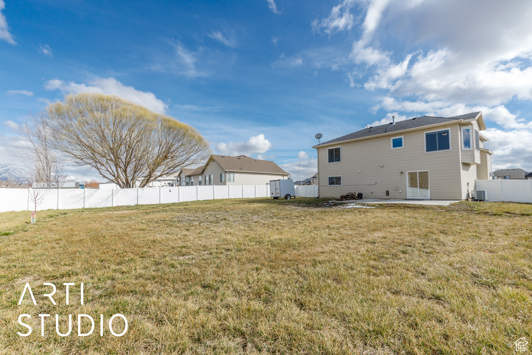 Back of property featuring a patio area, cooling unit, a yard, and fence