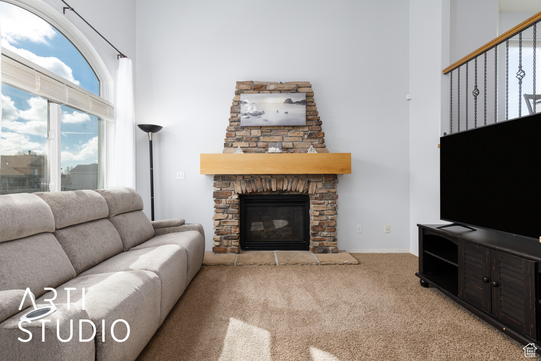 Carpeted living room featuring a high ceiling and a fireplace