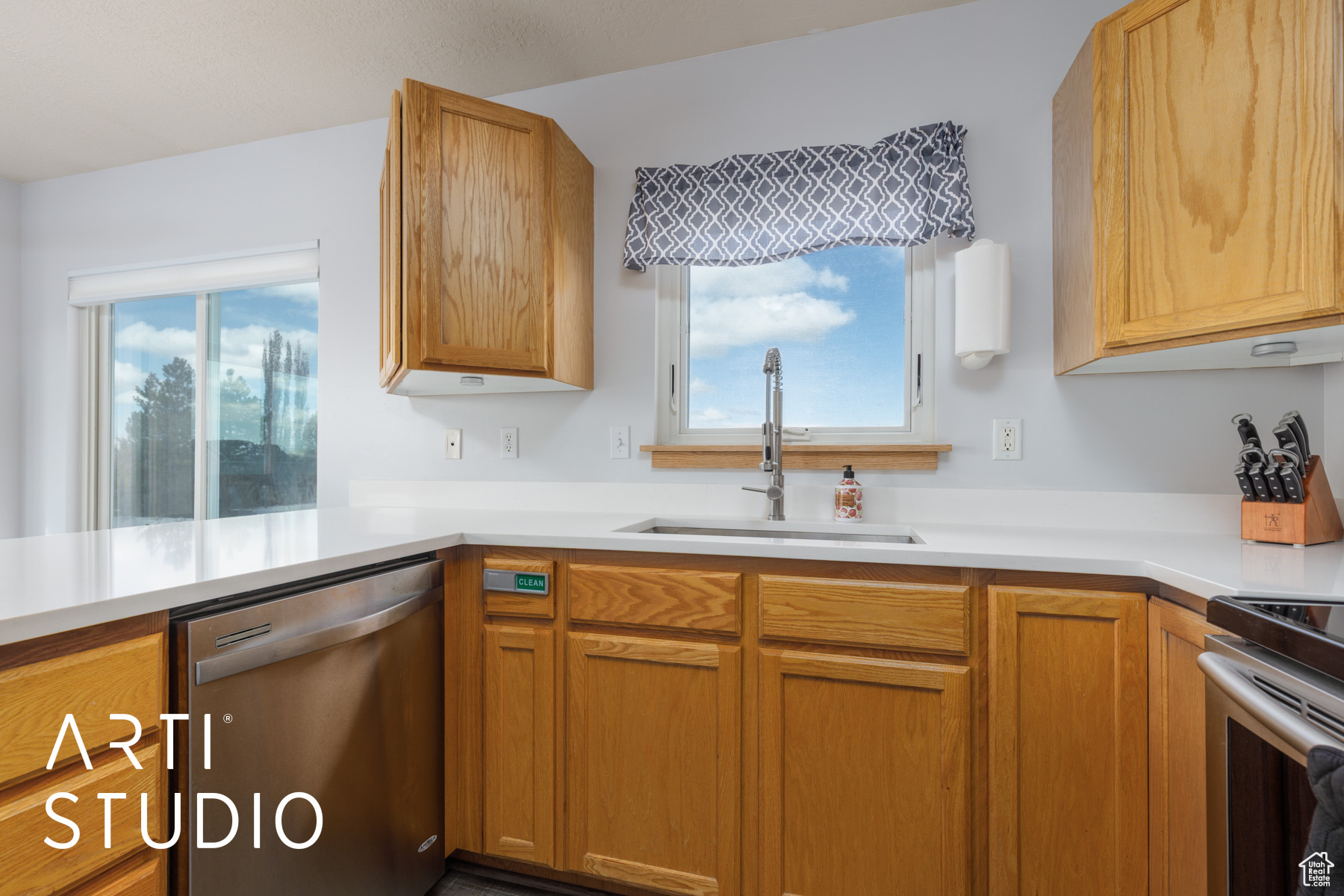 Kitchen with a healthy amount of sunlight, stainless steel appliances, light countertops, and a sink