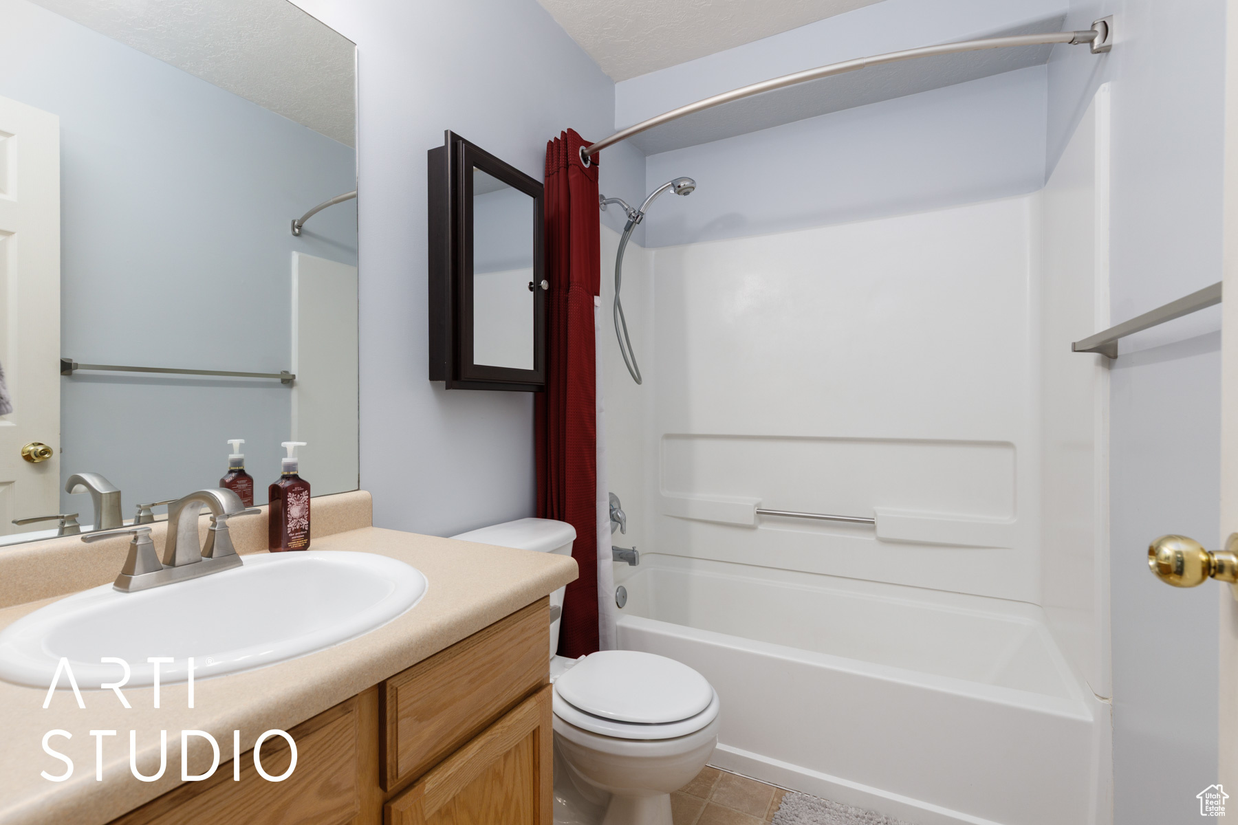 Bathroom with vanity, shower / bath combination, tile patterned flooring, a textured ceiling, and toilet