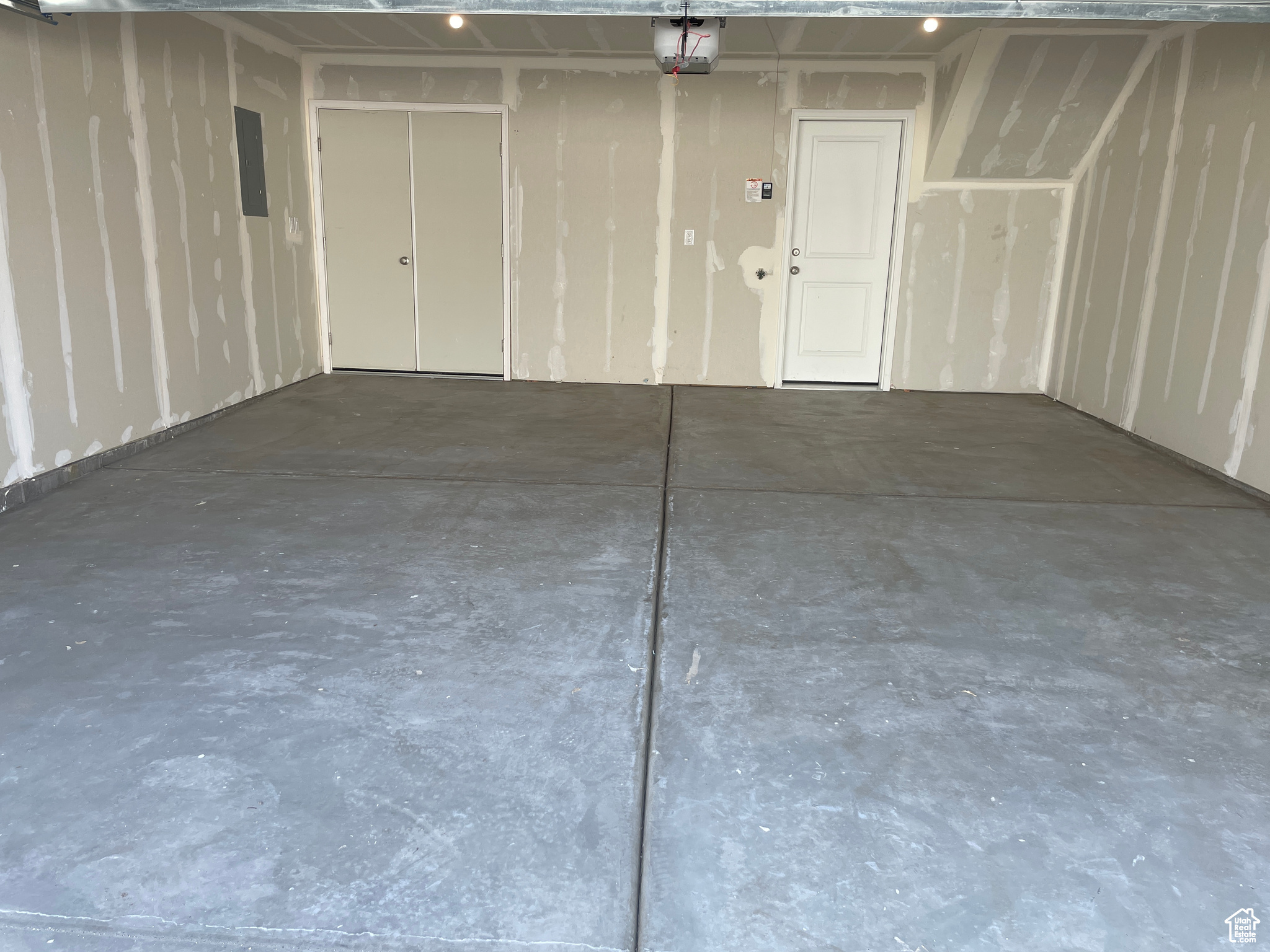 Garage featuring electric panel and a garage door opener