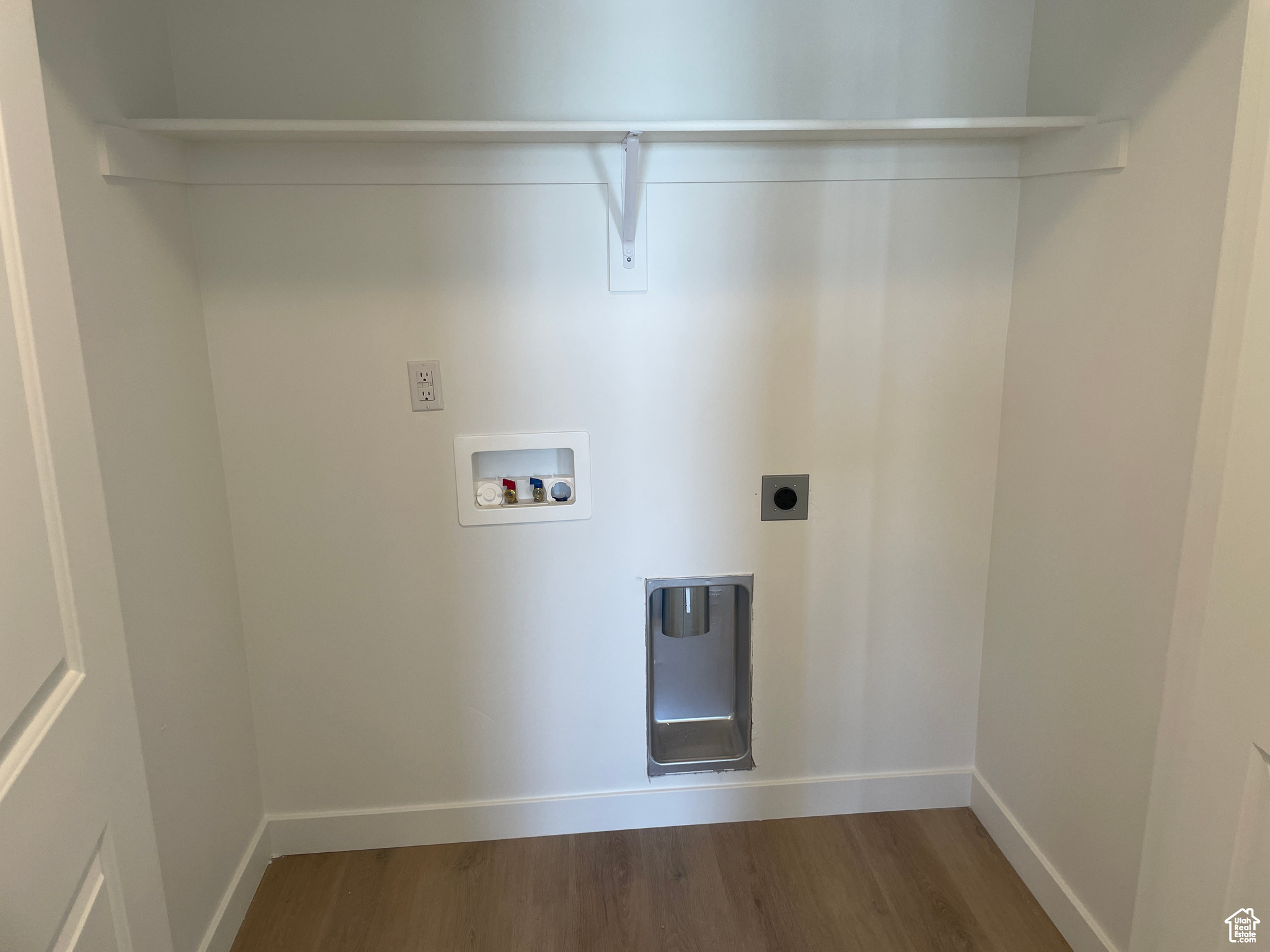 Clothes washing area with hookup for a washing machine, wood finished floors, baseboards, hookup for an electric dryer, and laundry area