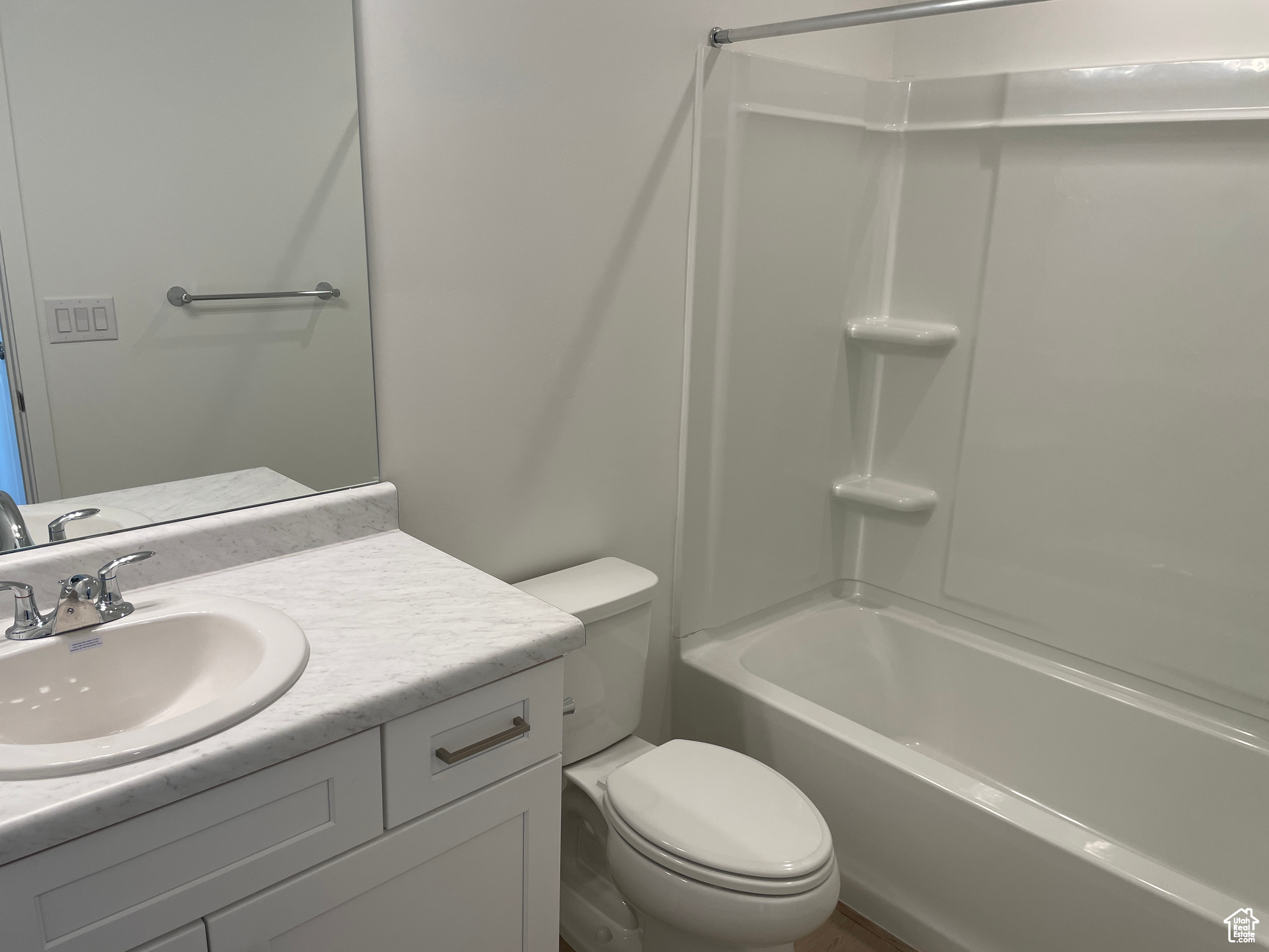 Bathroom featuring shower / bathing tub combination, toilet, and vanity