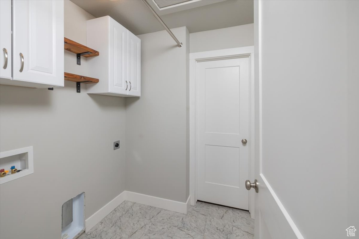 Washroom featuring baseboards, hookup for a washing machine, cabinet space, hookup for an electric dryer, and marble finish floor