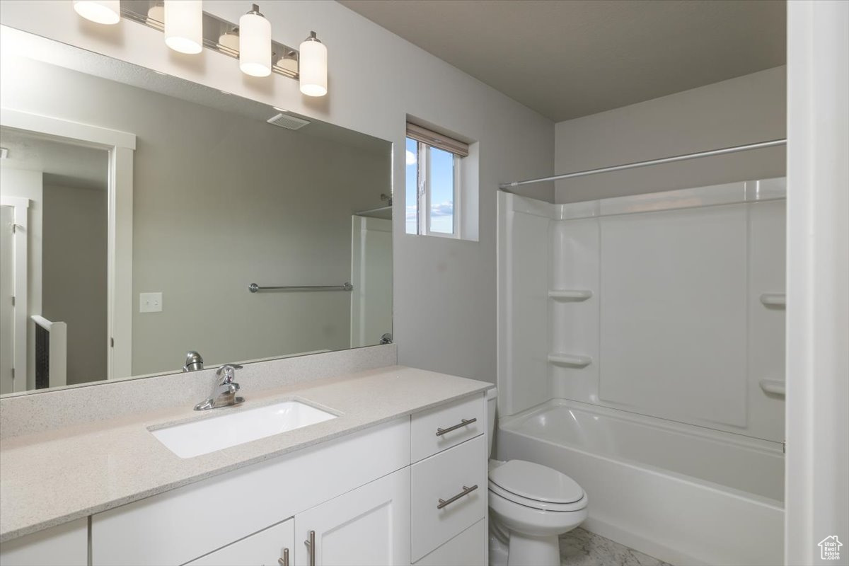 Bathroom featuring shower / bathing tub combination, toilet, visible vents, and vanity