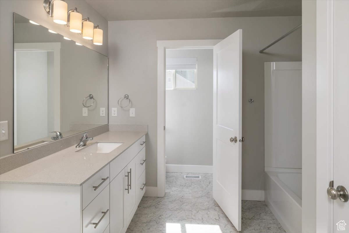 Bathroom featuring marble finish floor, vanity, and baseboards