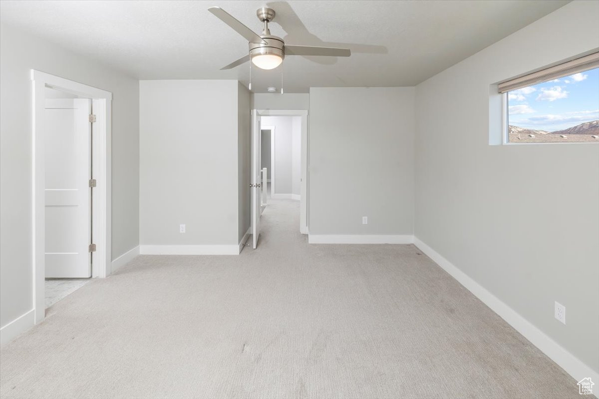 Unfurnished bedroom with a ceiling fan, baseboards, and light carpet