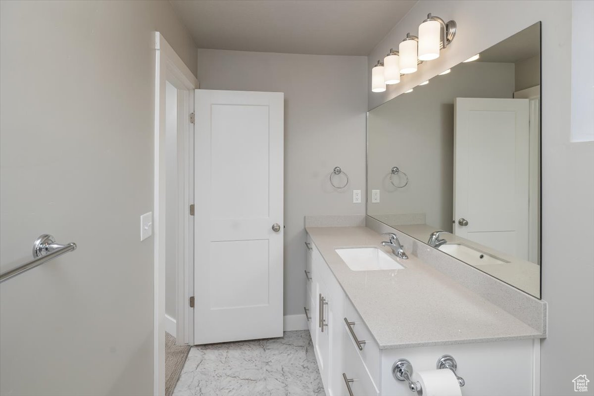 Bathroom with baseboards, marble finish floor, and vanity