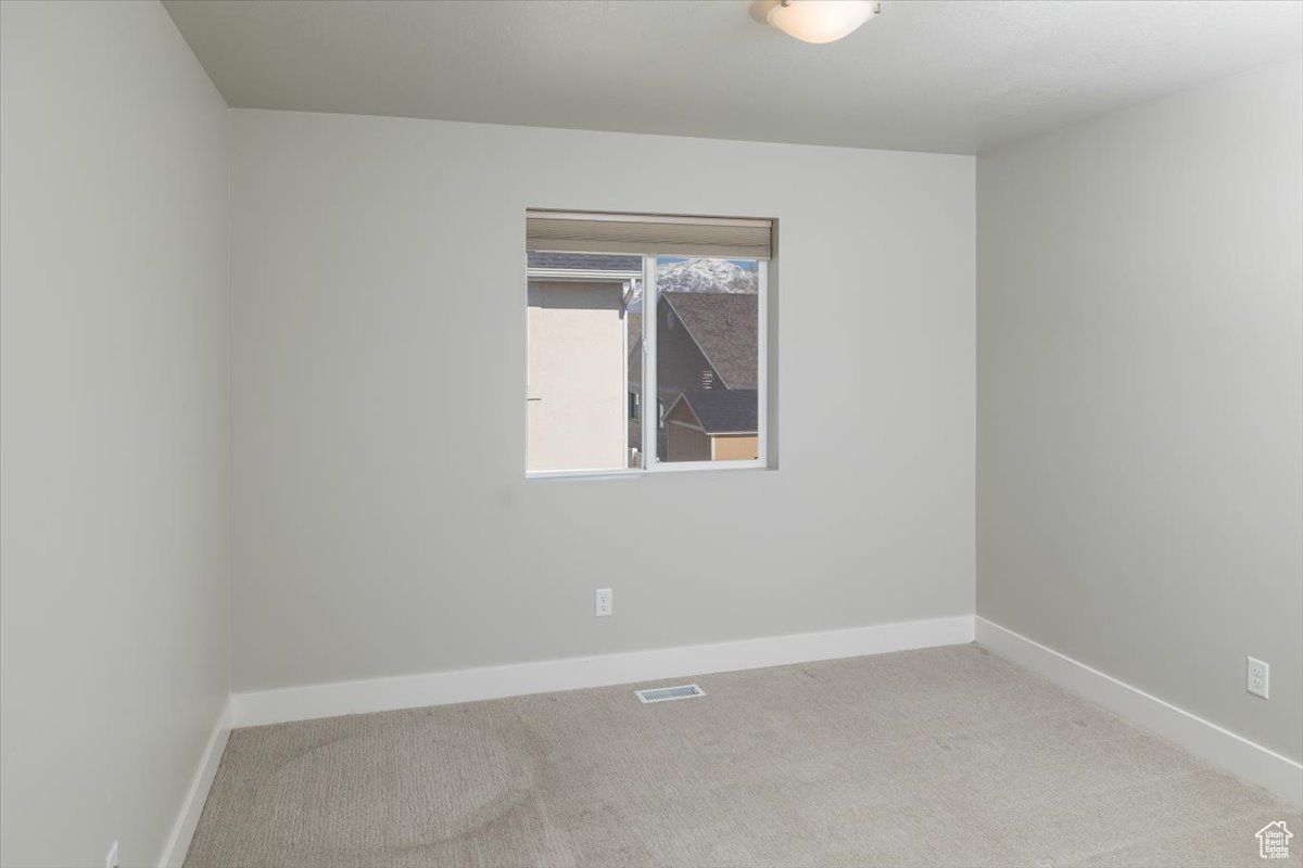 Unfurnished room featuring carpet, visible vents, and baseboards