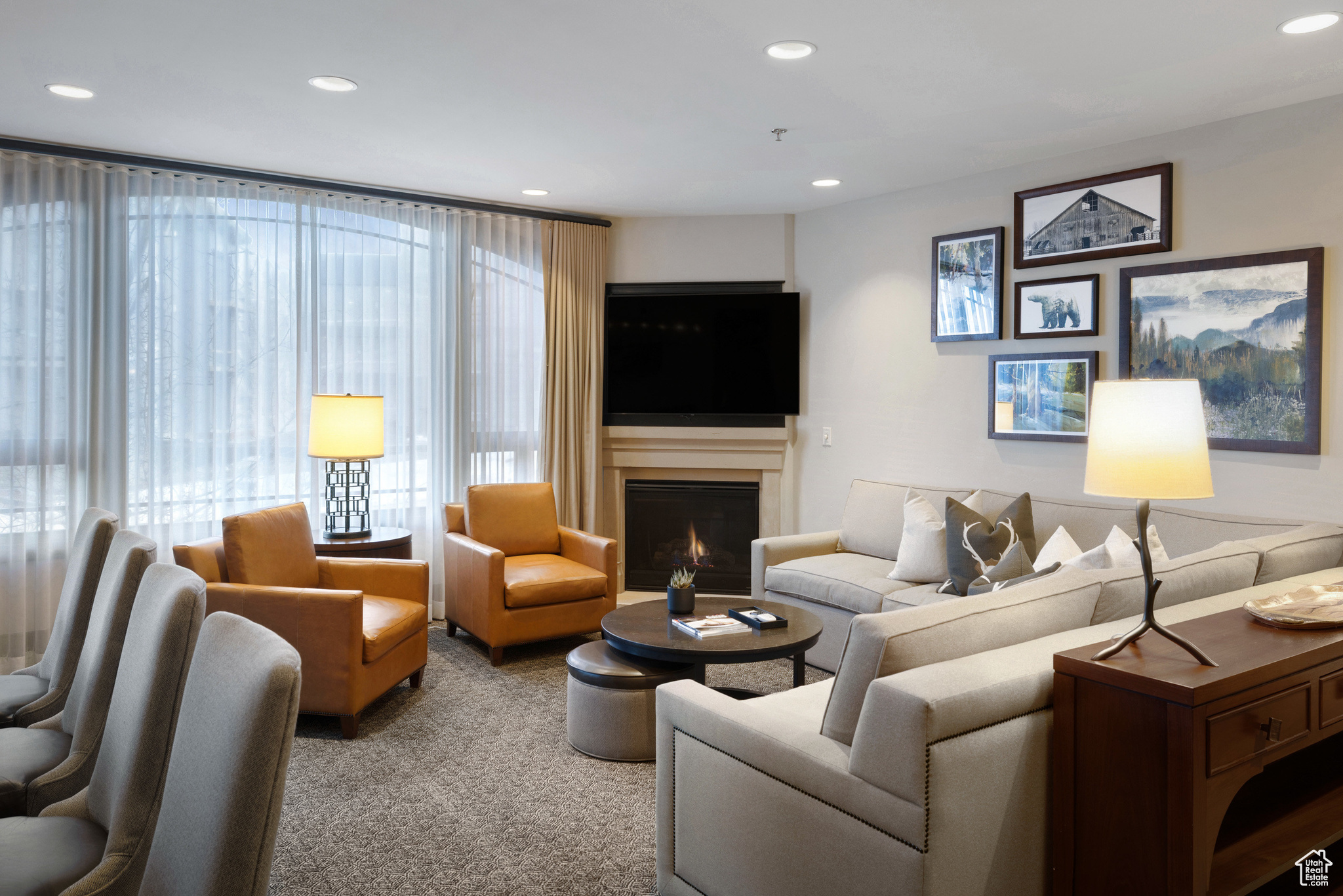 Living area with carpet flooring, recessed lighting, and a warm lit fireplace