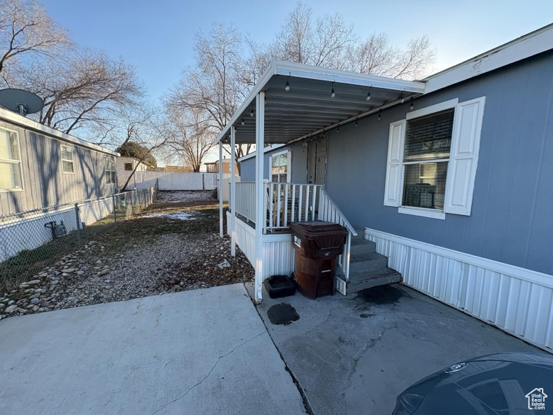 View of property exterior featuring a patio area and fence