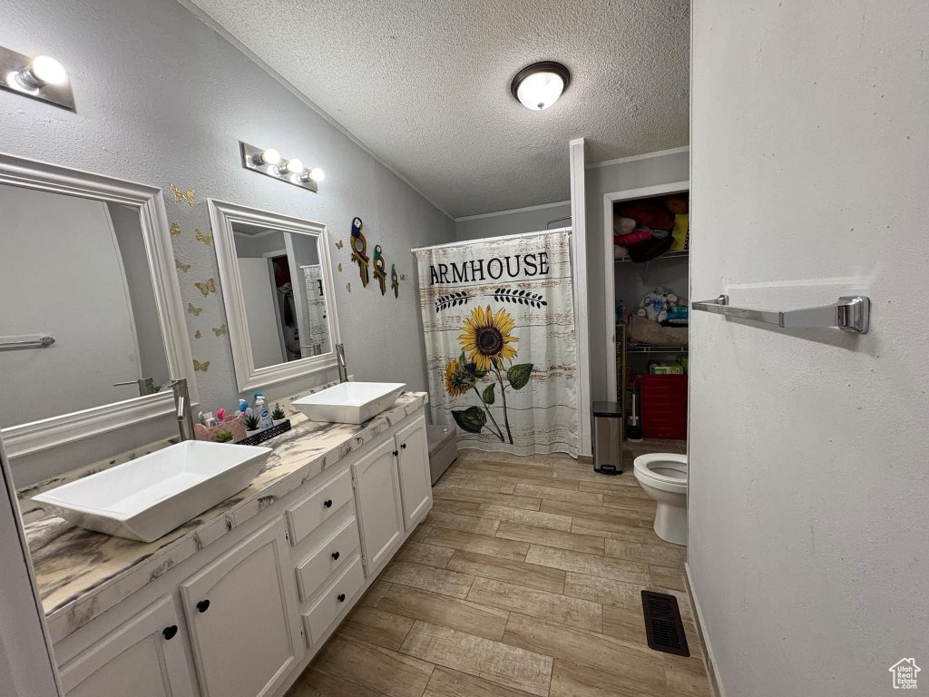Full bath featuring a sink, visible vents, wood finish floors, and toilet