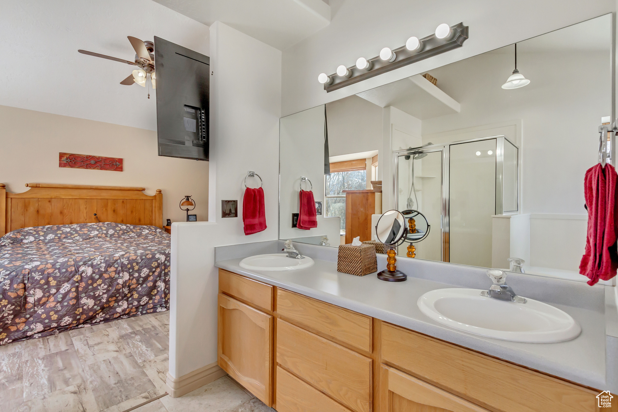 Full bathroom with double vanity, a stall shower, and a sink