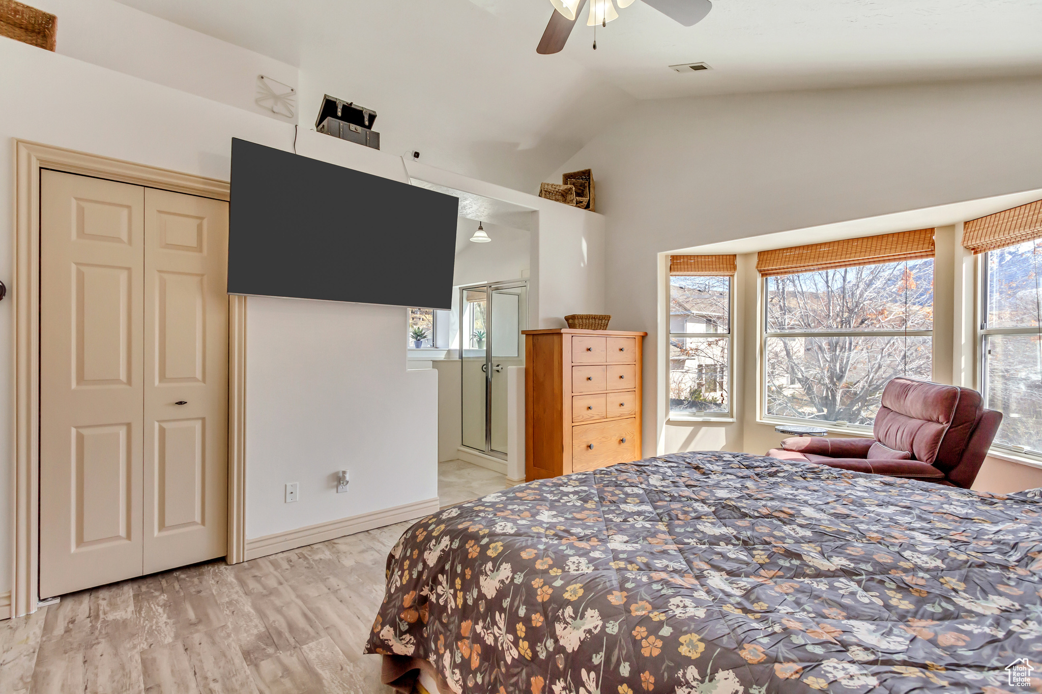 Bedroom featuring visible vents, light wood-style floors, ceiling fan, and vaulted ceiling