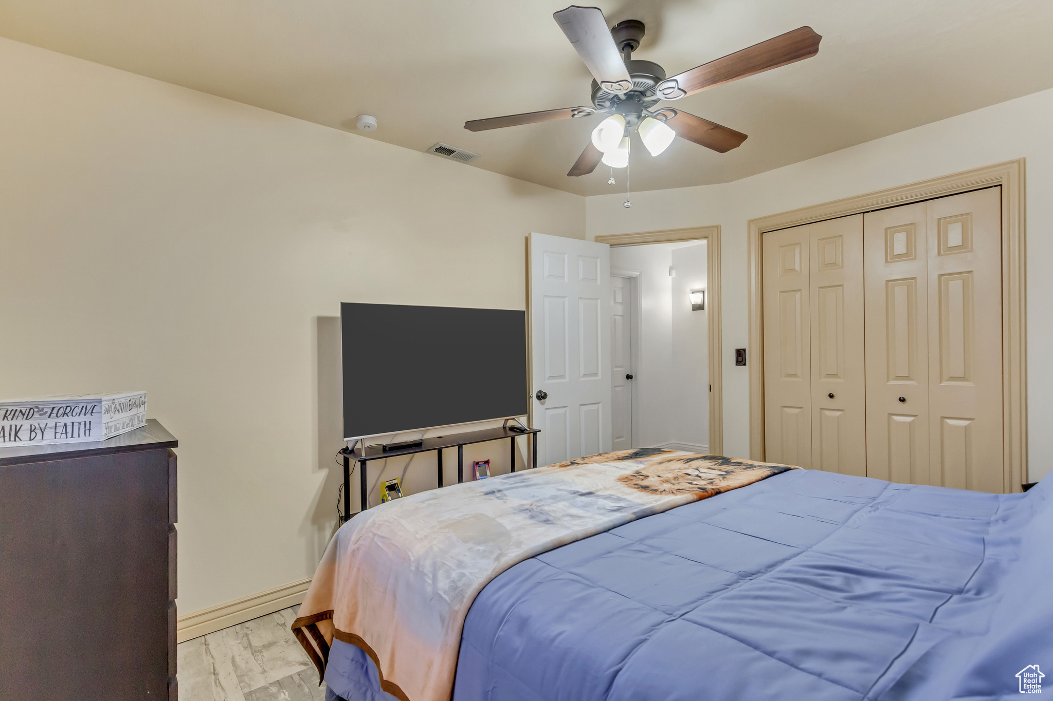 Bedroom with visible vents, ceiling fan, baseboards, light wood-style floors, and a closet