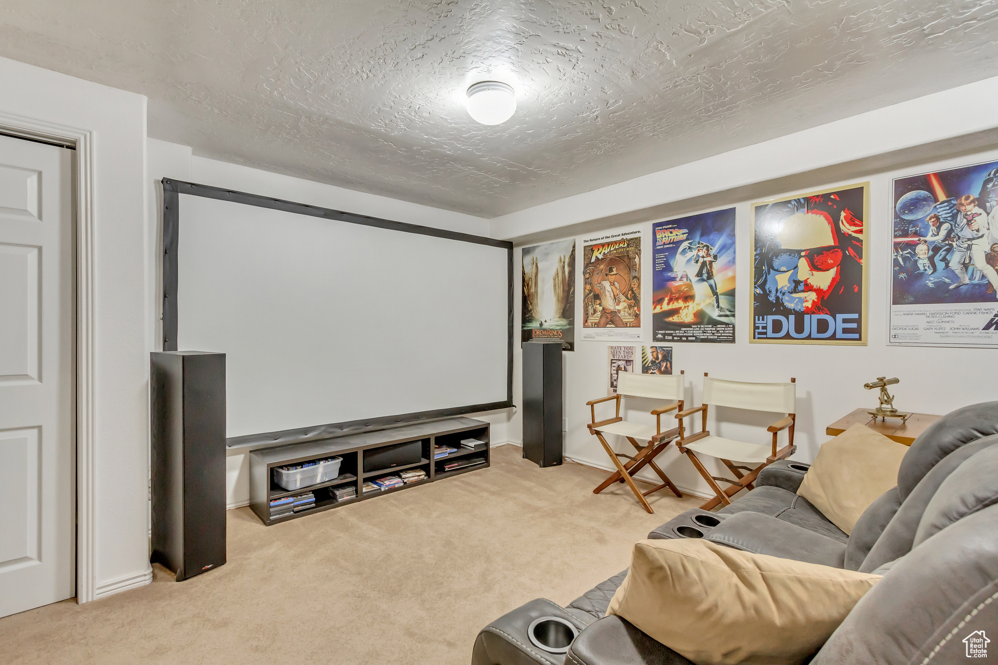 Carpeted home theater room featuring a textured ceiling