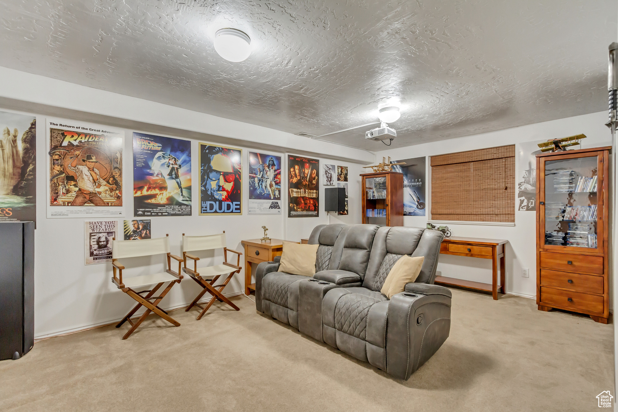 Living area featuring a textured ceiling, baseboards, and light carpet
