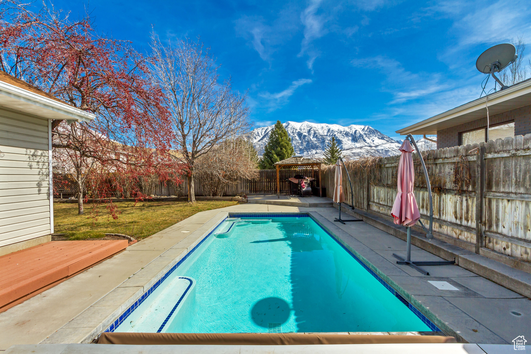 View of swimming pool with a fenced in pool, a deck with mountain view, and a fenced backyard