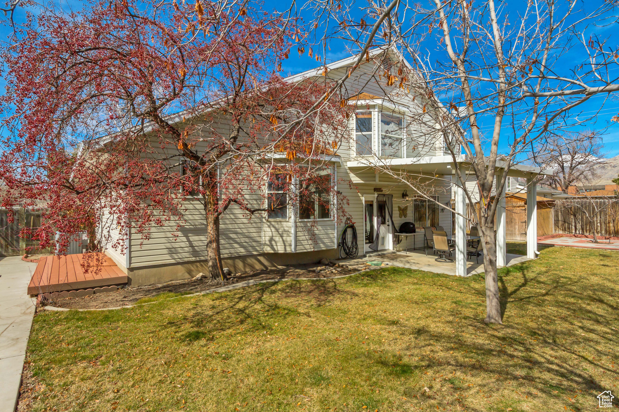 View of front of home featuring a front yard, a patio area, and fence