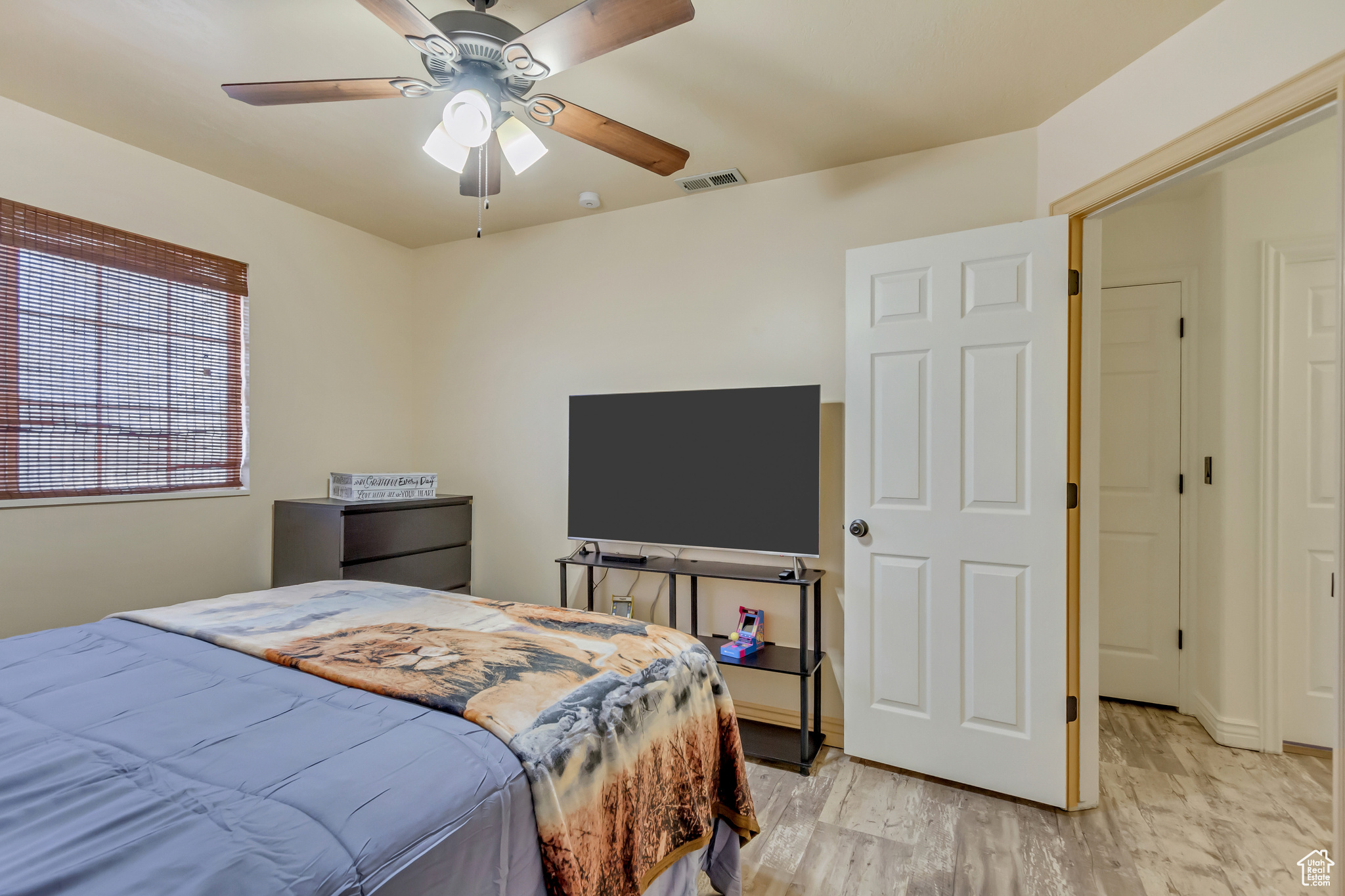 Bedroom featuring visible vents, light wood-style floors, and a ceiling fan
