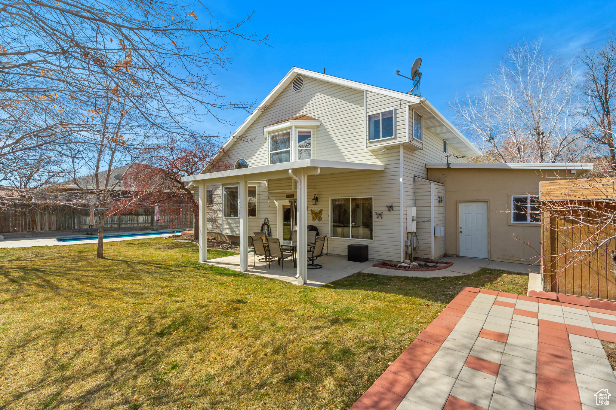 Back of house featuring a patio area, a yard, a fenced in pool, and fence
