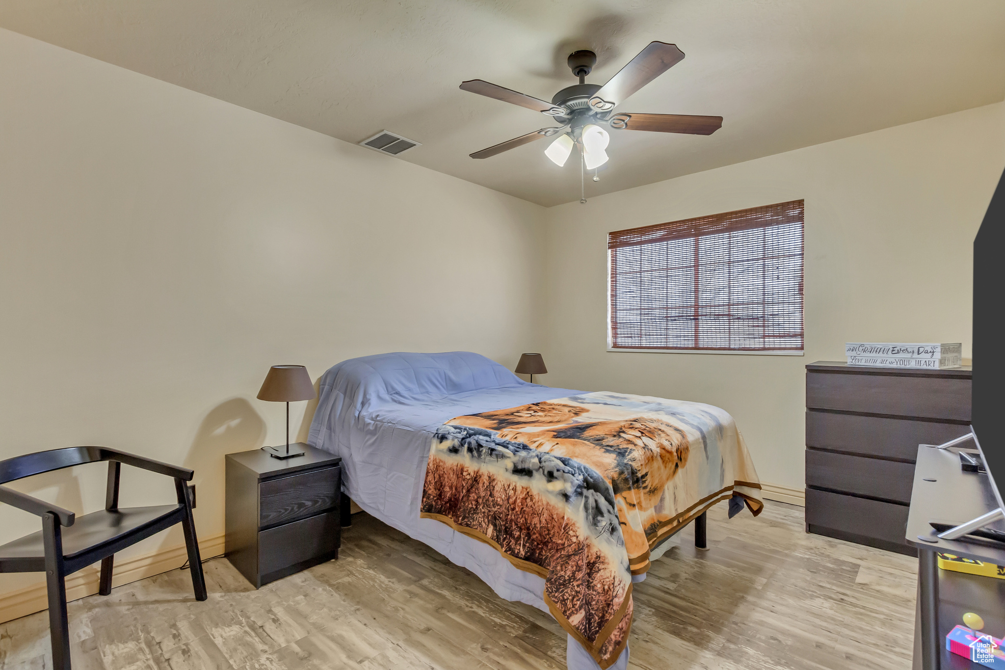 Bedroom featuring visible vents, baseboards, light wood-style floors, and a ceiling fan