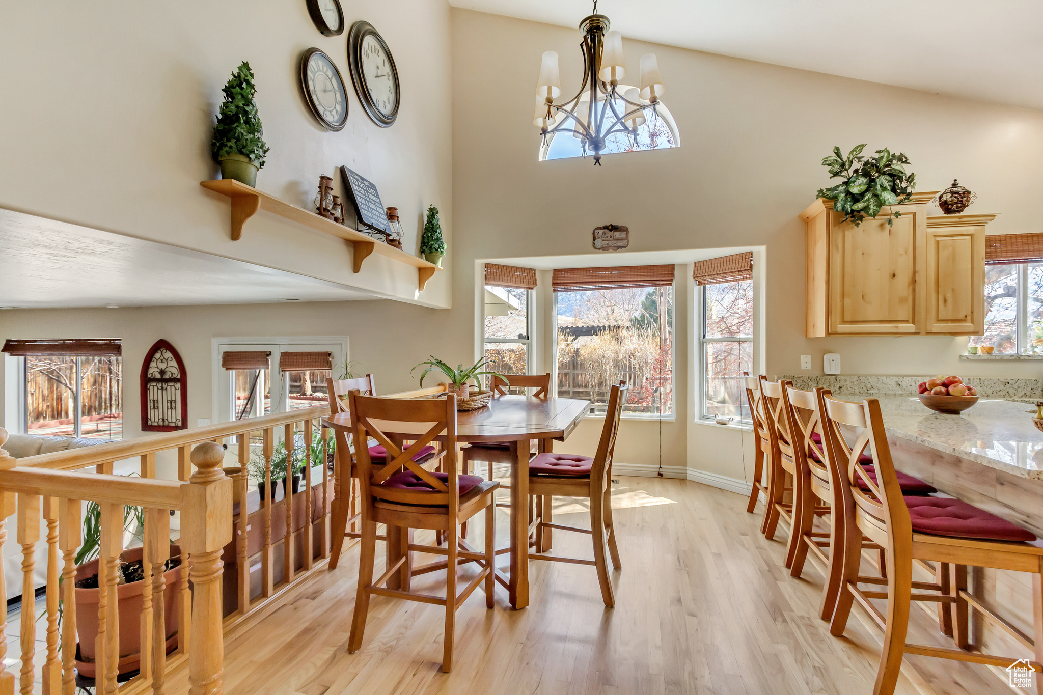 Dining room with a high ceiling, a notable chandelier, light wood-style floors, and baseboards