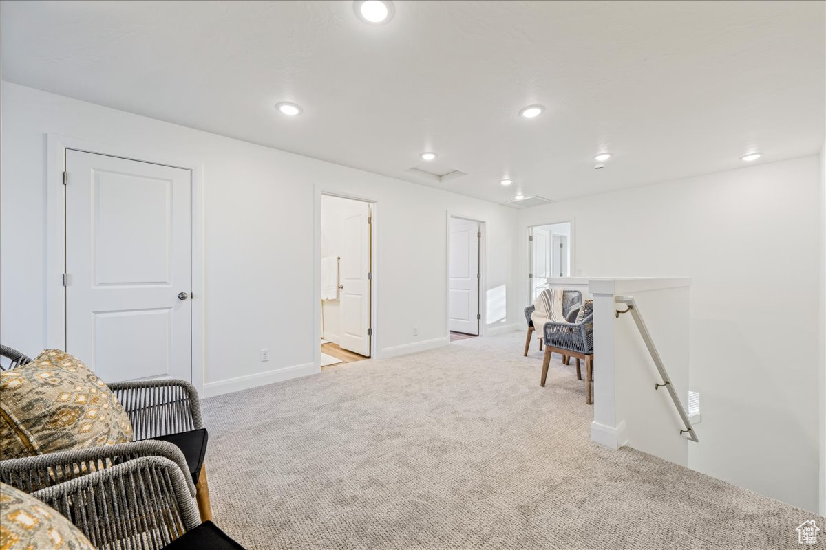 Living area featuring an upstairs landing, carpet flooring, recessed lighting, and baseboards