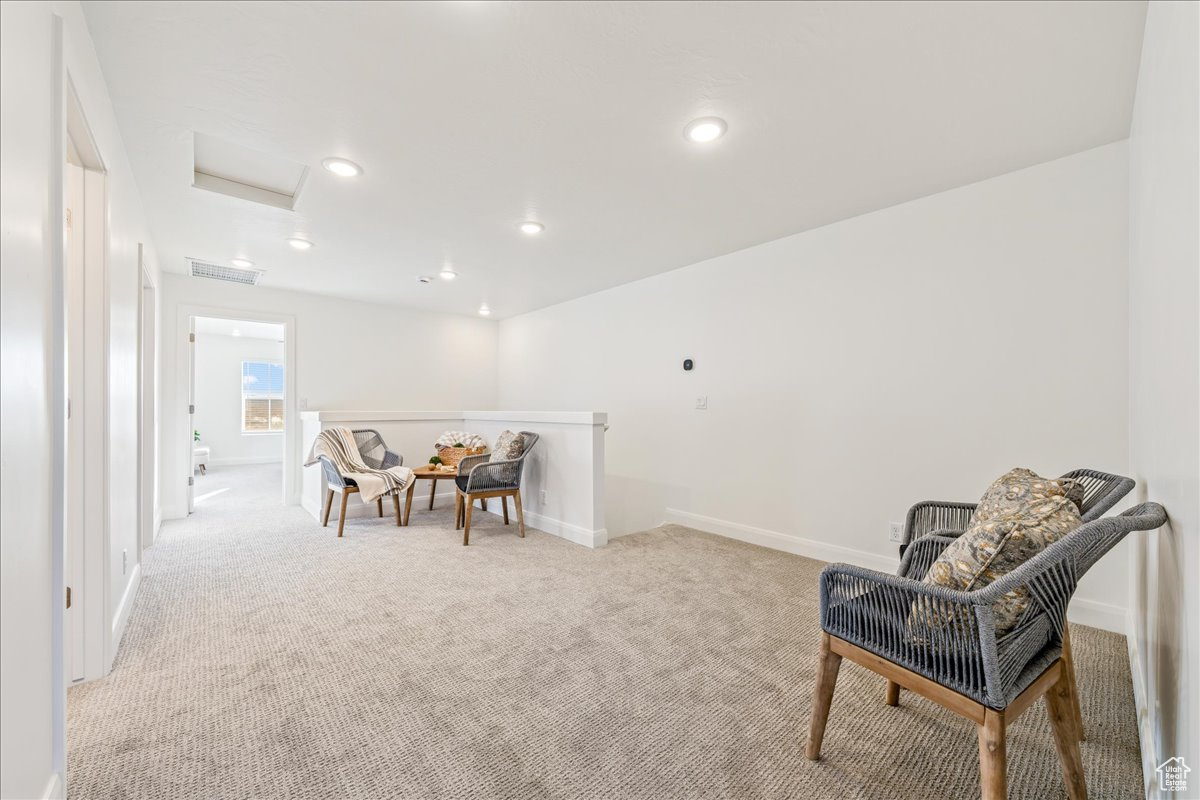 Sitting room with visible vents, baseboards, light colored carpet, attic access, and recessed lighting