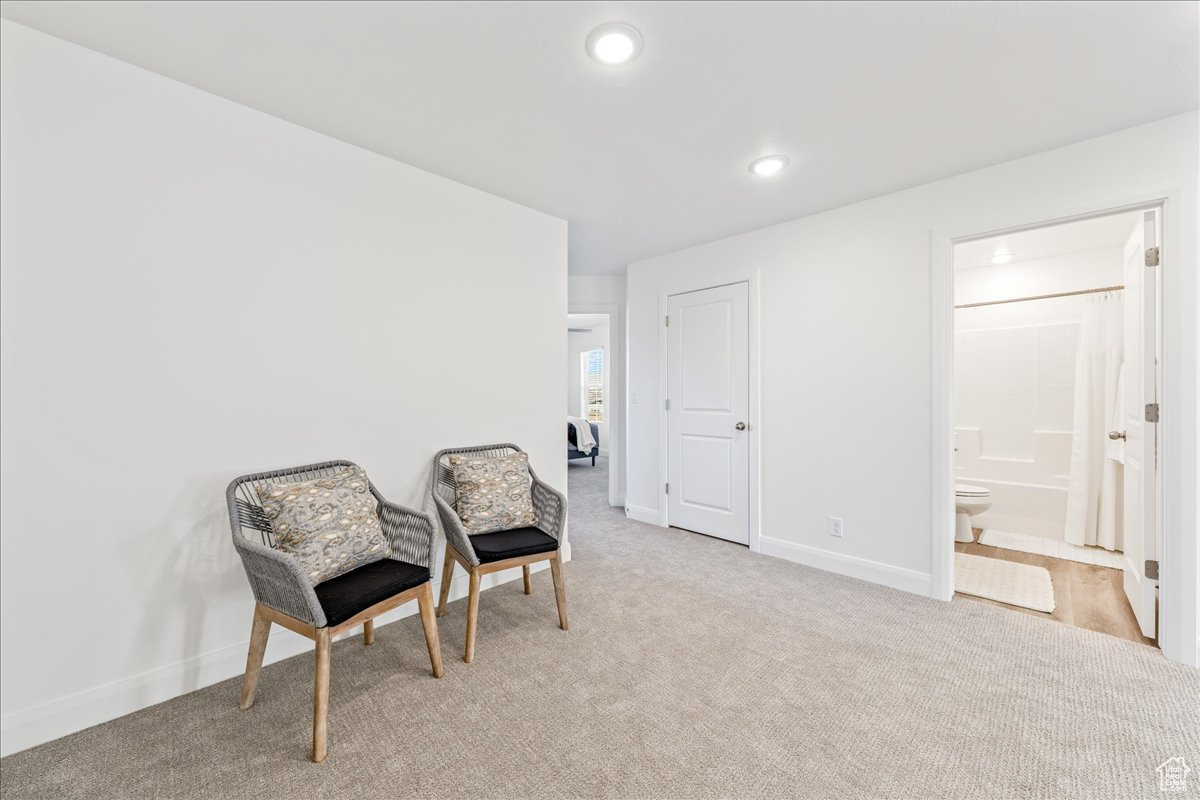 Living area with recessed lighting, baseboards, and carpet flooring